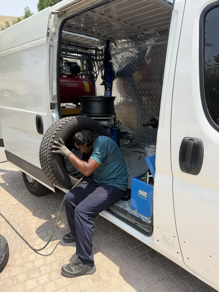Real mobile tyre technician working from the equipped service van in Dubai